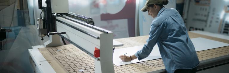 Person standing over a large printed sign